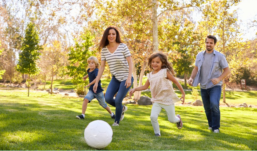 A family playing soccer in their backyard not having to worry about dog poop thanks to Scoopin Deuces, a dog poop removal service in Ocala, Florida.